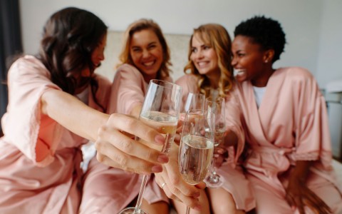 four women cheering a glass of champagne 