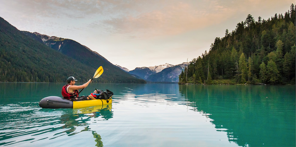 person kayaking on flat turquoise blue water