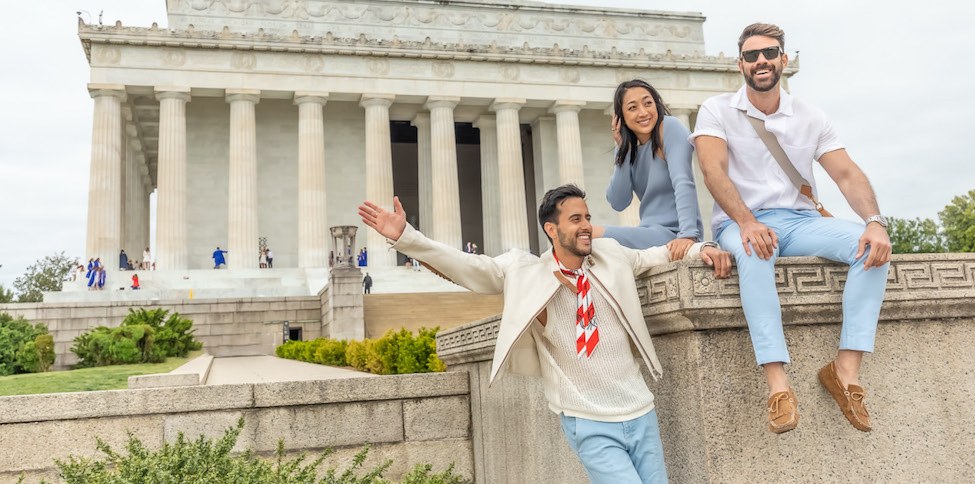 three friends sitting on stone wall in front of the lincoln memorial