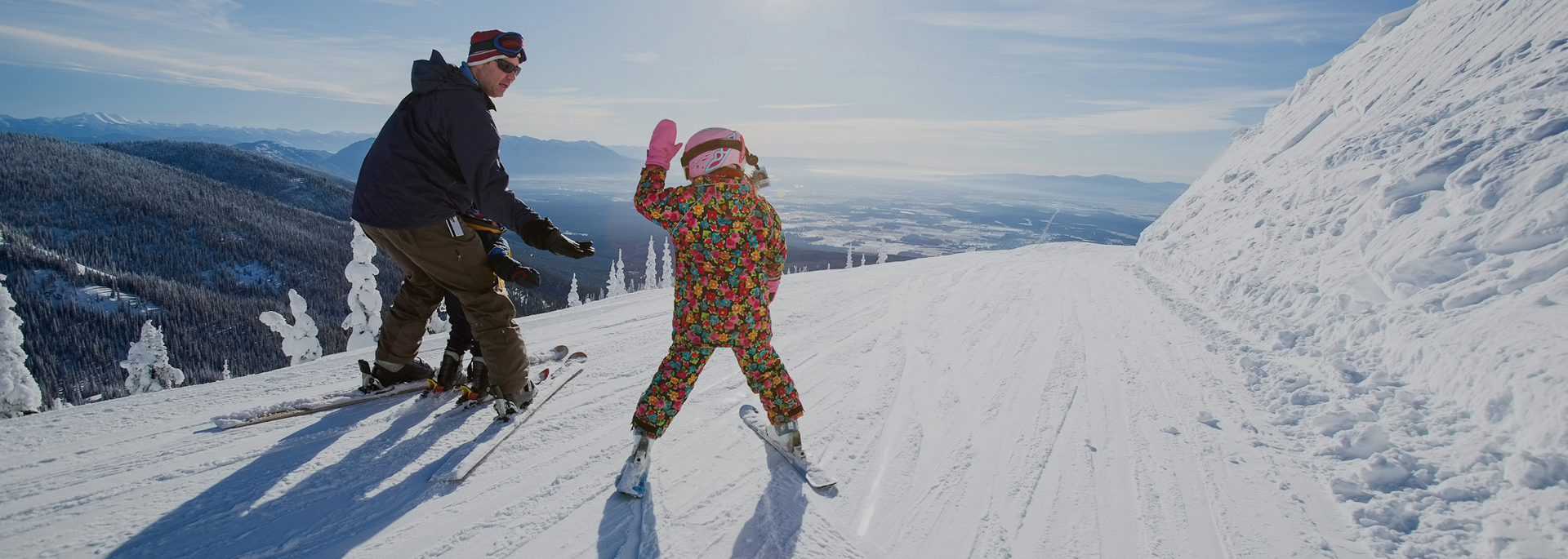 father and child high-fiving on skis