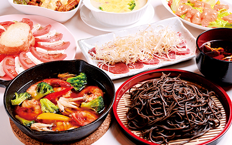 Dishes of soba noodles, cooked vegetables, and salad