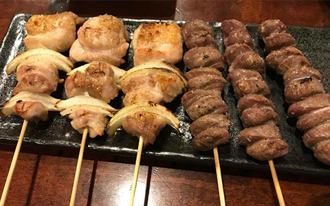 A plate with two types of yakitori (chicken skewers)
