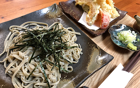A plate of soba noodles with a side dish of tempura