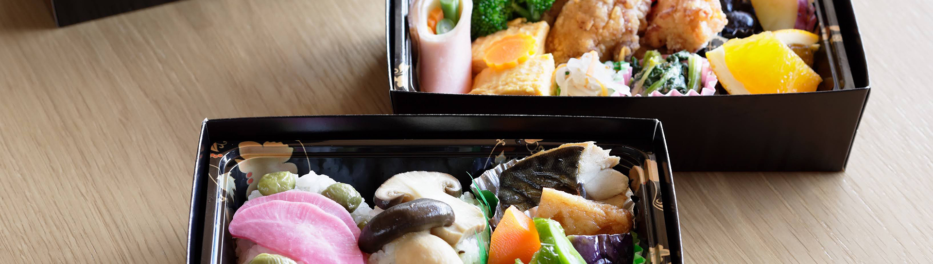 two japanese dishes in bento boxes
