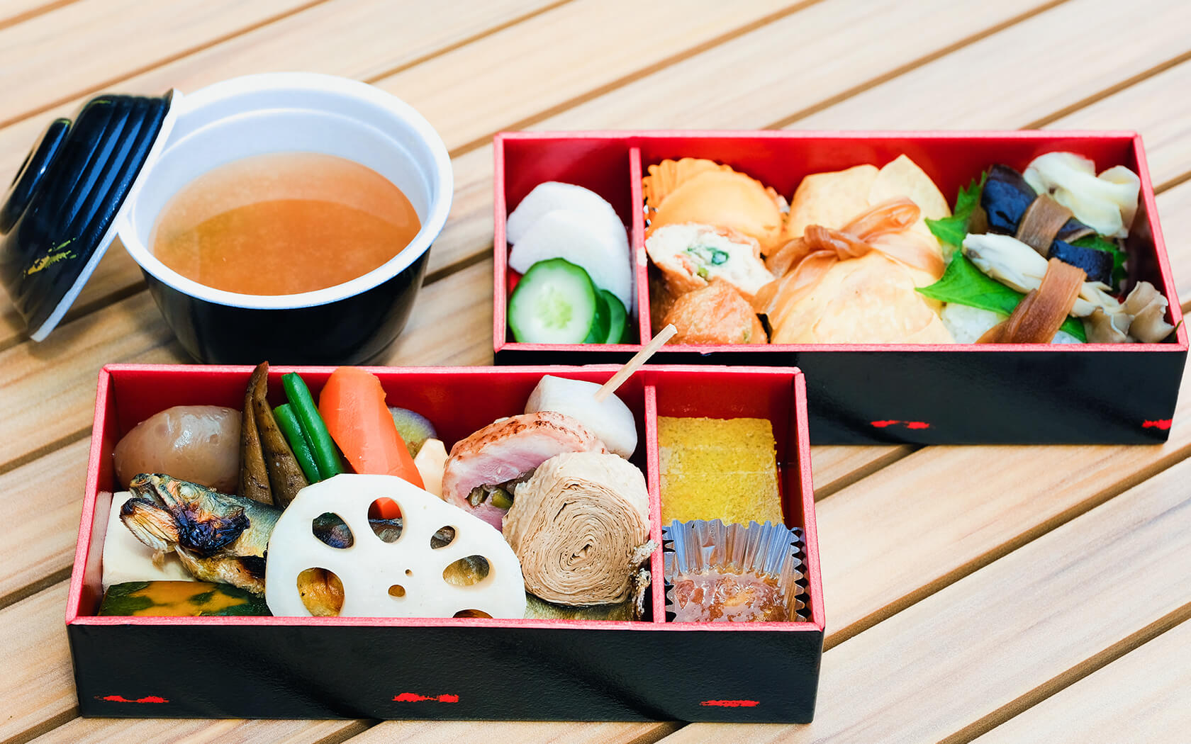 two bento boxes with food and vegetables found in the traditional Japanese cuisine