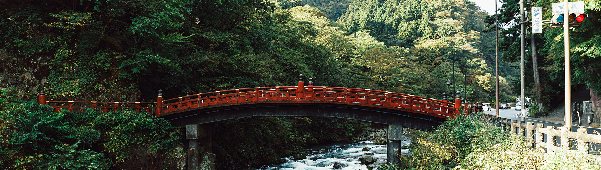 traditional japanese bridge with red accents in the forest