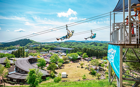View of Mobility Resort Motegi with guests sliding down the zip line