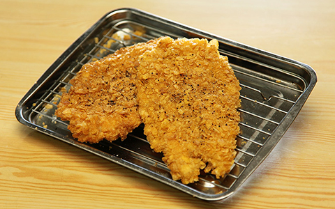 A plate with two pieces of fried chicken