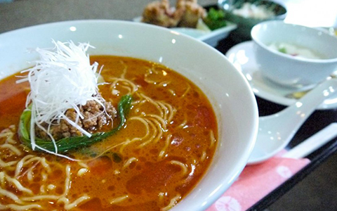 Hot spicy noodles served with soup and salad
