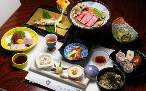 A traditional Japanese course meal with beef, fish, sashimi, and rice