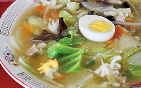 Bowl of ramen with vegetables and topped with a boiled egg