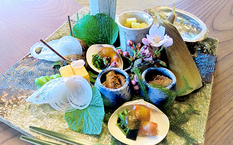 Various Kaiseki dishes served on small plates and decorated with flowers