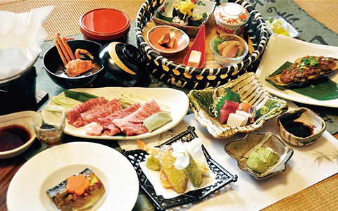 A set meal of grilled vegetables, tempura, sashimi, and meat