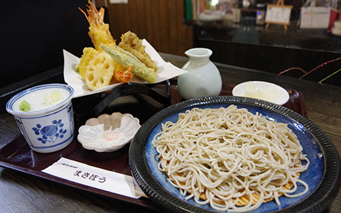 A plate of cold soba noodles with a side dish of tempura