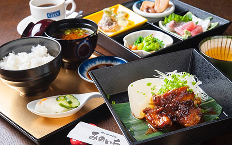 A set meal of sashimi, grilled meat, vegetables, rice, and miso soup