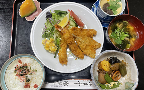 A plate of deep-fried cutlet with salad on the side, miso soup, and rice
