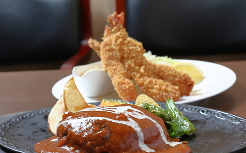 Fried shrimp and hamburger steak served with vegetables