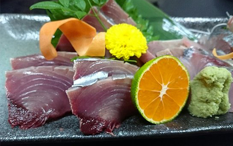 A plate of sliced sashimi served with wasabi