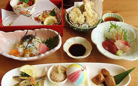 Small dishes of sashimi, tempura and salad