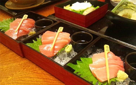 Divided portions of sashimi with wasabi and soy sauce