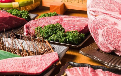 Different types of pre-cooked meat on black plates