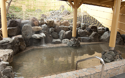 An outdoor hot spring with a roof at Springs Hiyoshi Onsen in Kyoto