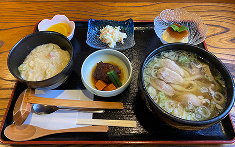 A set meal with hot udon, rice, boiled vegetables, and desssert
