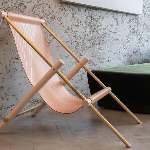 A pink chair and a green couch behind it. 