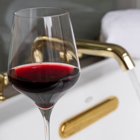 A glass of wine on a tub. 