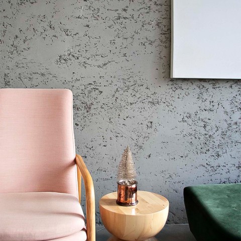 A pink chair with a wood table. 