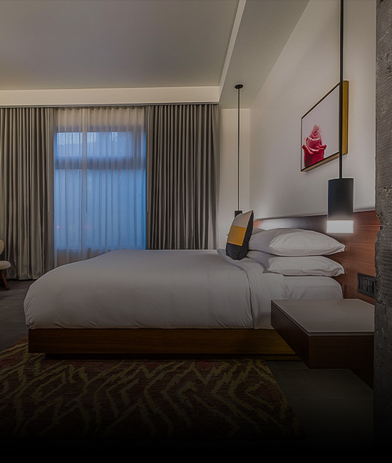 Bedroom with a bed and multiple pillows and a painting hanging above it