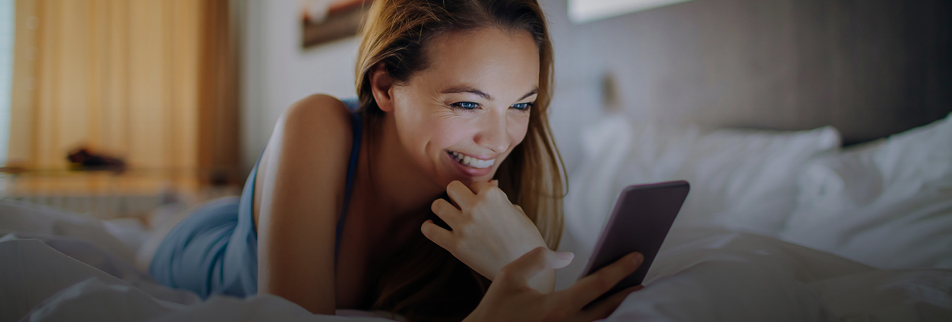 a woman on a bed looking at her cellphone