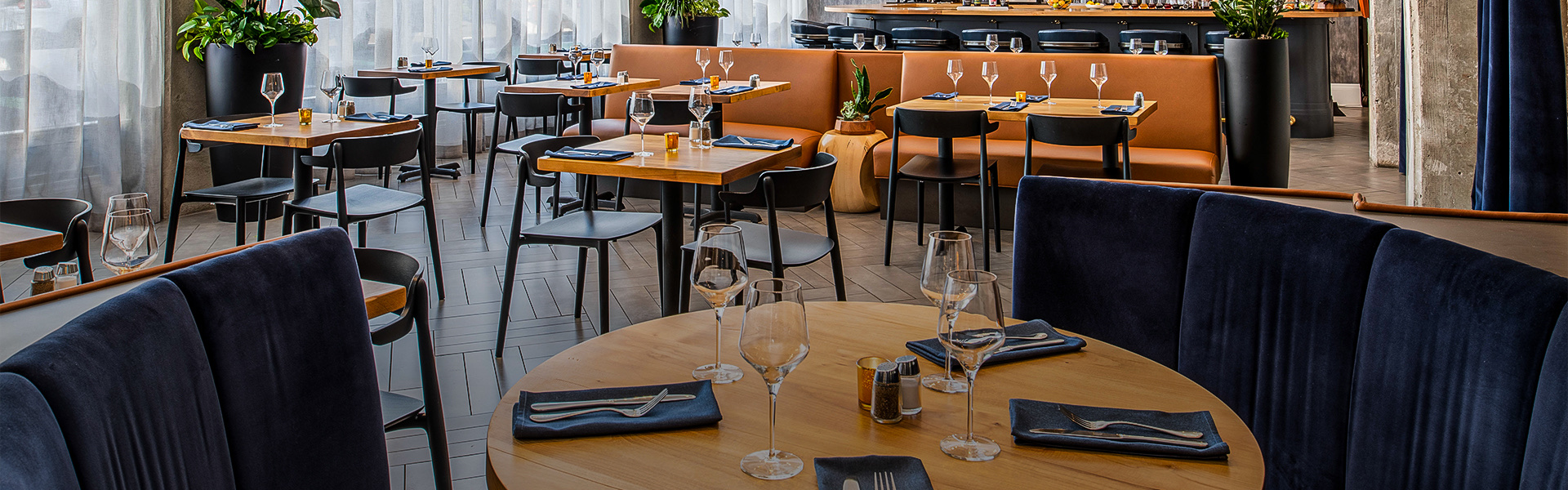 A restaurant with dining tables and some glasses on top of it