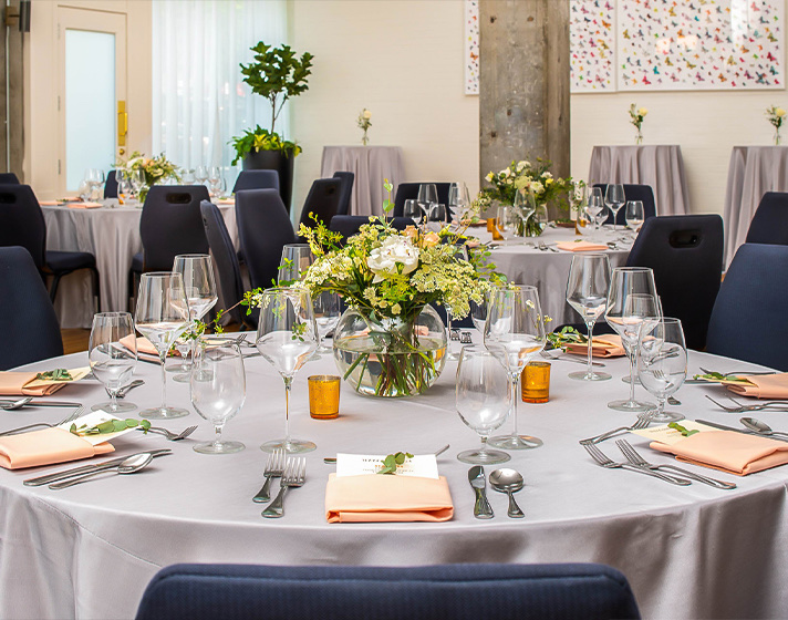 An event hall with dining tables and glasses on top of it