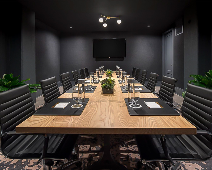 a meeting room with a large table and black chairs