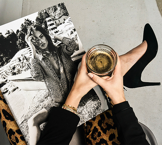 A woman holding a magazine and a glass