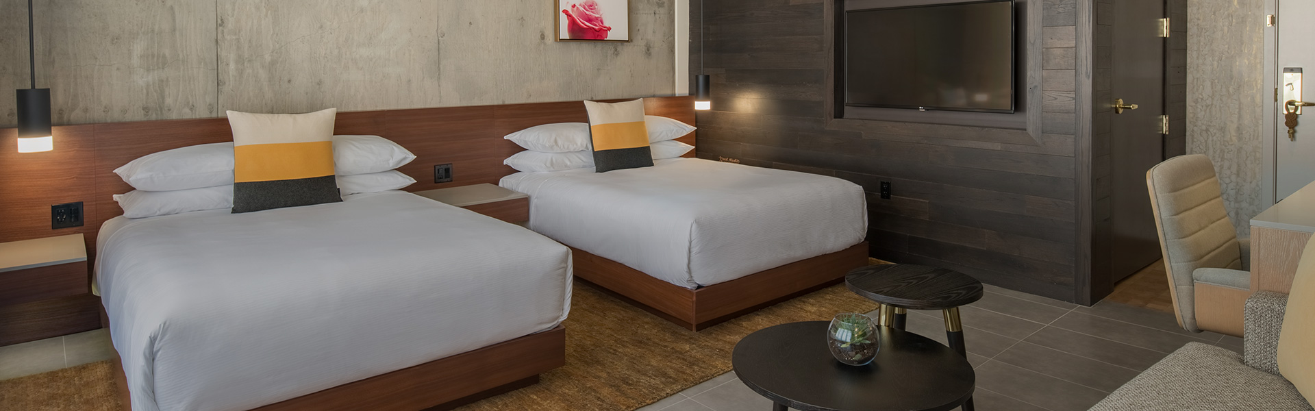 double beds in a hotel room with accent pillows