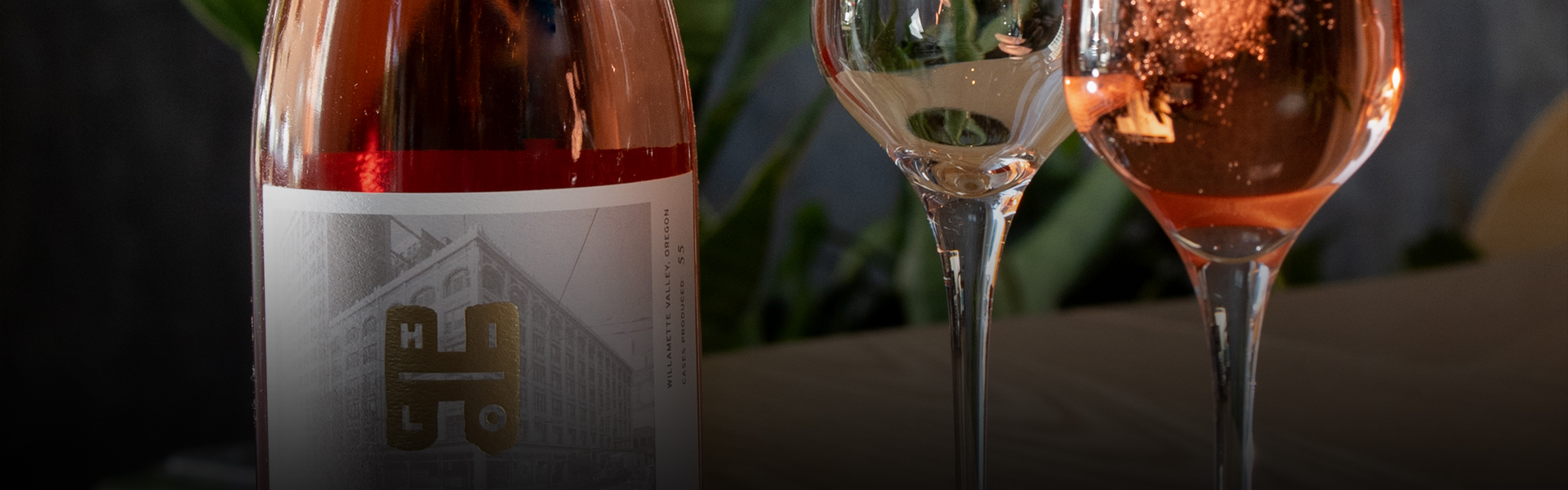 close up of a rose bottle of wine and two champagne glasses