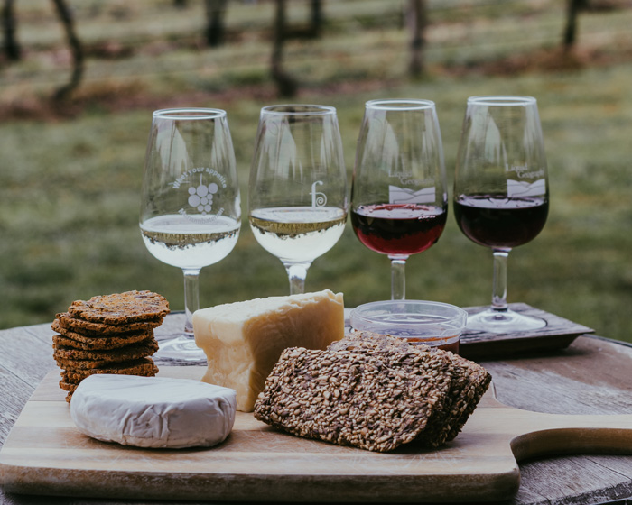 four wine glasses on a table with bread