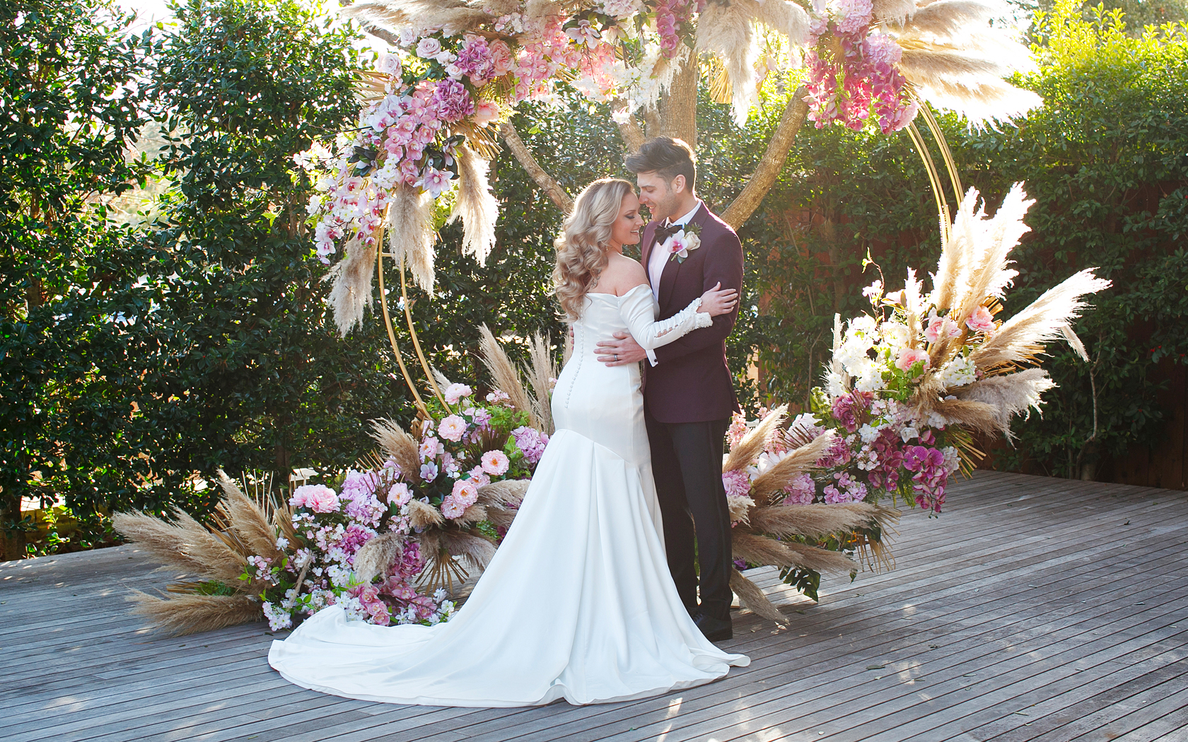 bride and groom next to floral arrangement