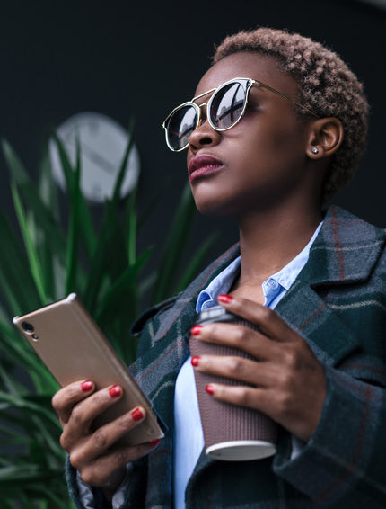 person in action holding a coffee and a phone