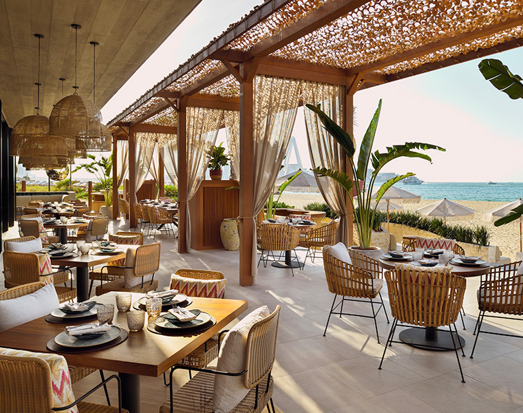 dining with an outdoor breeze and view of the beach