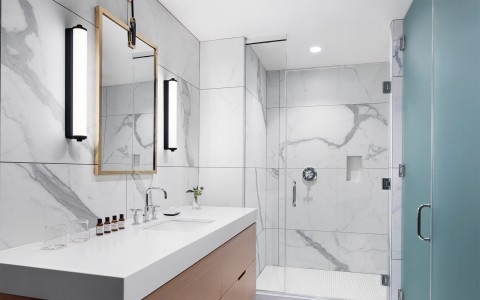 a bathroom with white and gray marble walls