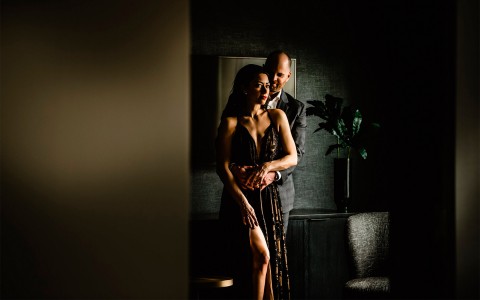 a man and woman hugging in a low lit room