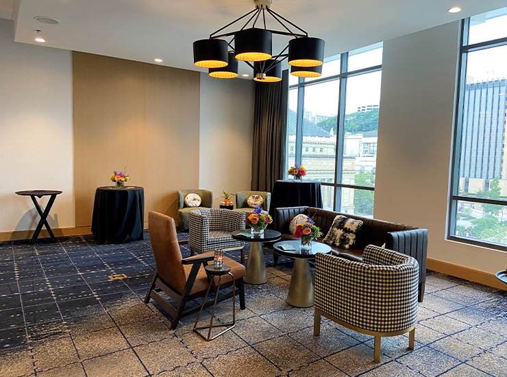 a seating are with a black sofa and tan chairs