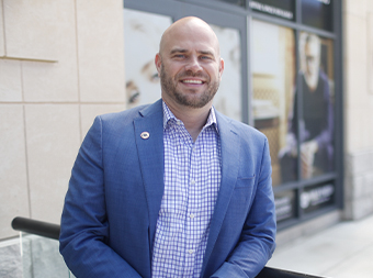 a smiling man wearing a blue blazer