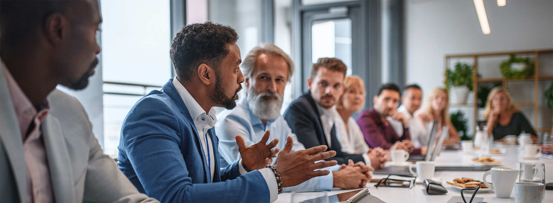 a group of business people talking at a table during a meeting