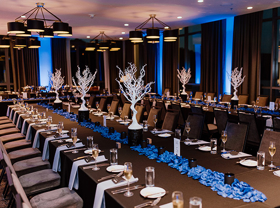 a dim lit event room with black linen tables