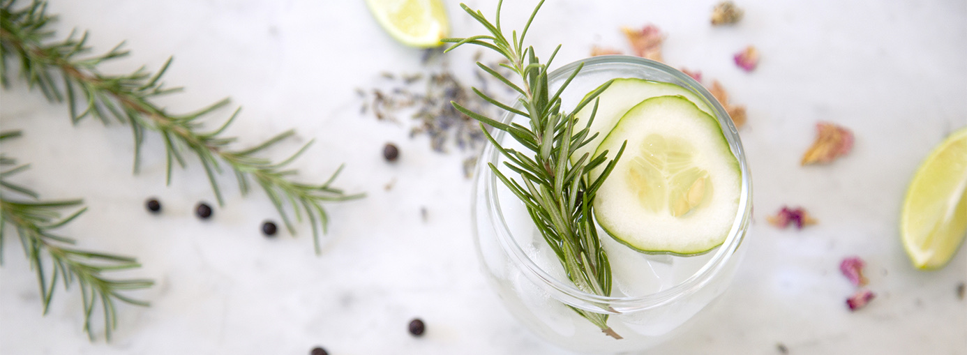 Jar of water with cucumber slices and rosemary leaves