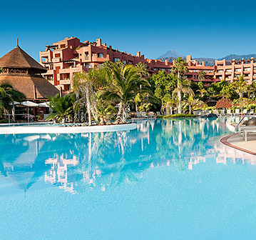 crystal blue pool amidst rocky mountains and palm trees